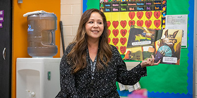 Ms Grijalva holding up book illustration