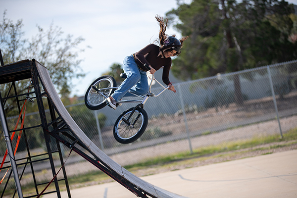 A woman goes down a ramp on a BMX bike