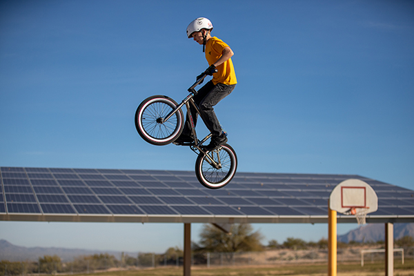 A boy flies high in the air on a BMX bike