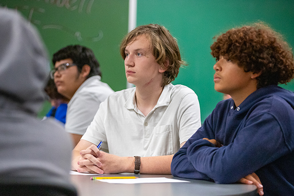 Three teen boys listen to the career panel