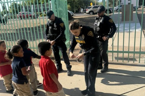 A female police officer greets students